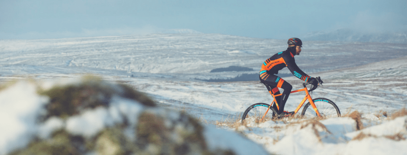 Man biking on trail through snowy scenery