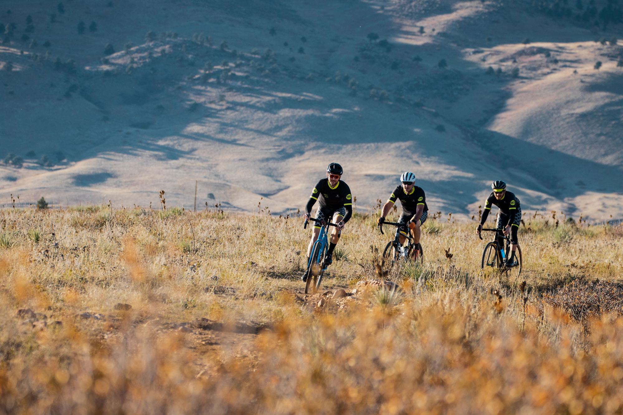 Three cyclists riding on mountain trail