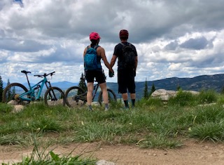 Heather and Kevin Cappon holding hands while enjoying the scenery during bike riding break